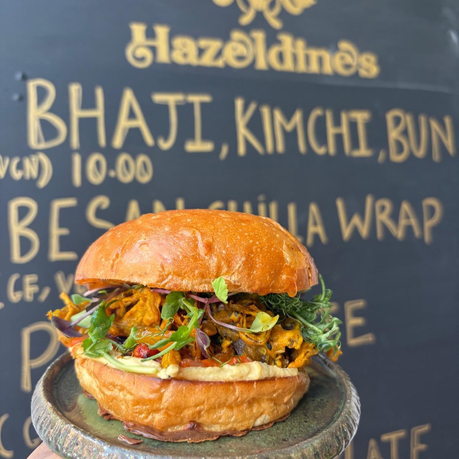 The Bhaji Kimchi Bun held up at the counter